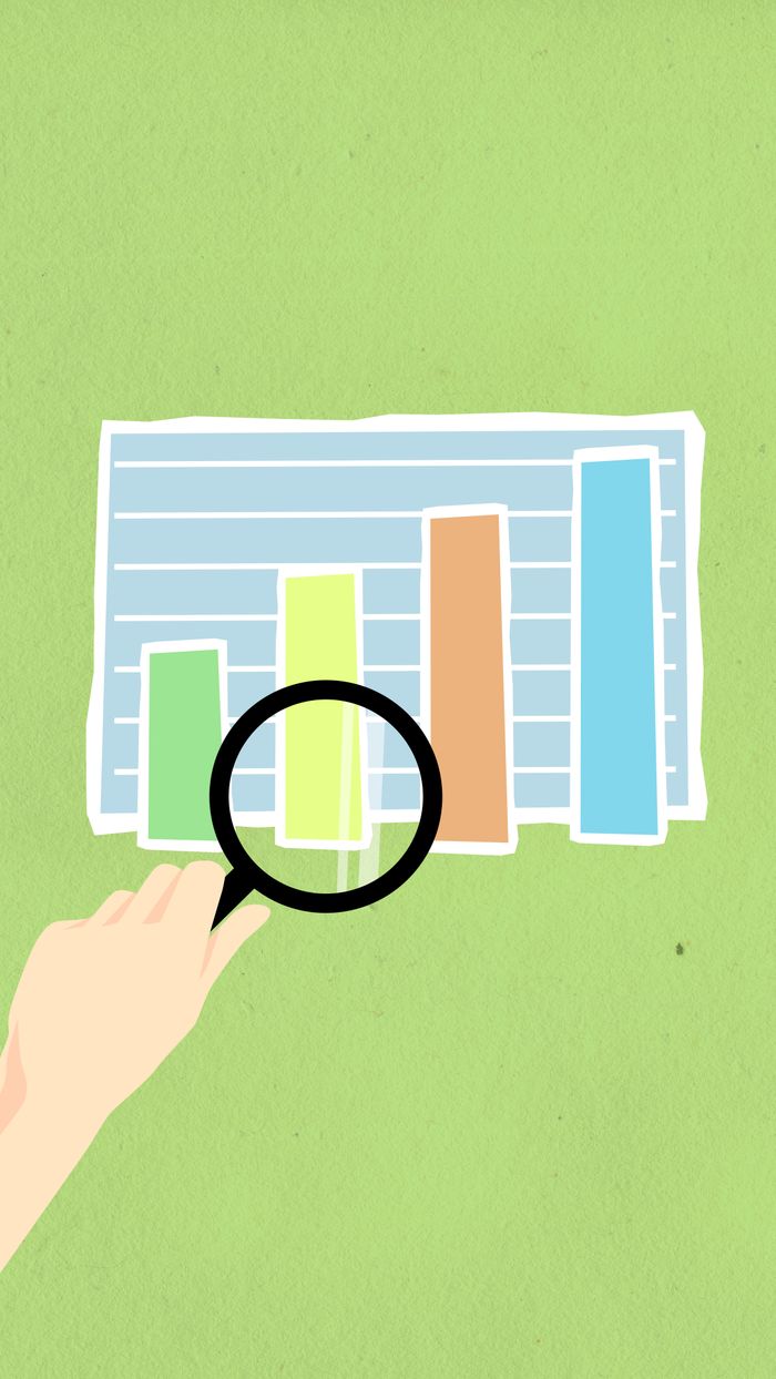 Bird’s-eye view of a decorative cardboard illustration showing a hand holding a magnifying glass over a diagram with columns on a green background